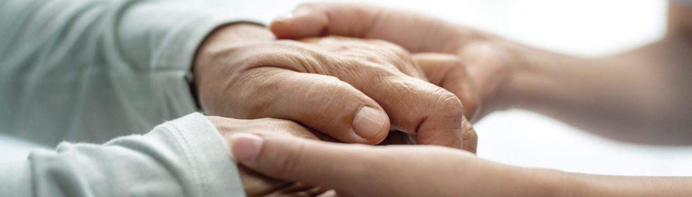 Compassionate Elderly Care and Support Caregiver holding the hands of an elderly person